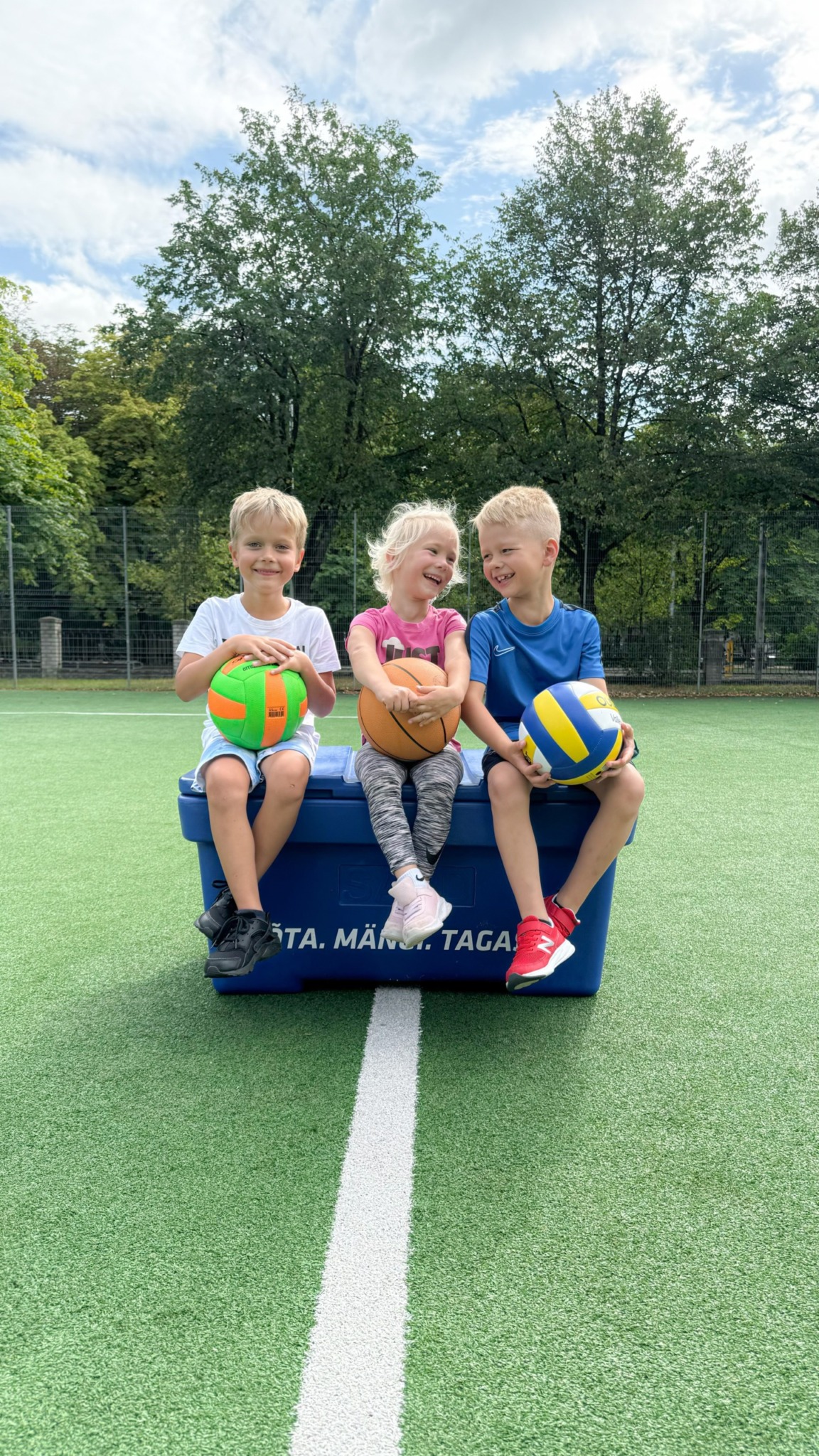 Lapsed avaliku spordiväljaku pallikasti juures